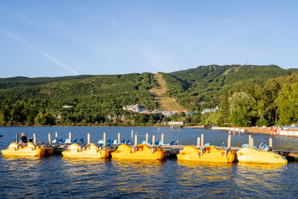 5 pédalos jaunes alignés au quaie de la plage du Lac Tremblant